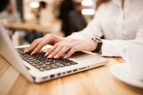 女性の手とパソコンのキーボード